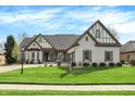 Charming light brick home with Tudor accents, lush lawn, and a welcoming curb appeal at 14565 Geist Ridge Dr, Fishers, IN 46040