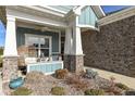 Inviting front porch with ceiling fan, wicker chair and built-in seating at 1574 Leisure Way, Greenfield, IN 46140