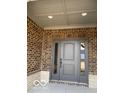 Charming gray front door with decorative glass sidelights and brick surround at 2212 Galleone Way, Plainfield, IN 46168
