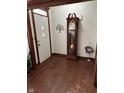 Bright entryway with hardwood floors, a large grandfather clock, and coat closet at 4 Downing Dr, Trafalgar, IN 46181
