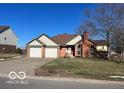 Brick ranch house with attached two-car garage and landscaped yard at 4 Downing Dr, Trafalgar, IN 46181