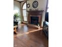 Spacious living room featuring hardwood floors, a brick fireplace, and large windows at 4 Downing Dr, Trafalgar, IN 46181