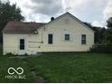 Rear view of a ranch home with a yellow exterior and a spacious backyard at 4025 N Kitley Ave, Indianapolis, IN 46226