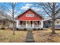 Inviting red house featuring a cozy front porch and landscaped front yard at 4616 Carrollton Ave, Indianapolis, IN 46205