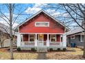 Charming red home with white trim, inviting porch, and well-maintained landscaping at 4616 Carrollton Ave, Indianapolis, IN 46205