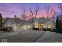 Charming single-story brick home featuring an attached two-car garage and a well-manicured lawn with light snow cover, set against winter trees at 4696 E County Road 100 S, Avon, IN 46123