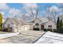 Charming single-story brick home featuring an attached two-car garage and a well-manicured lawn with snow cover, set against winter trees at 4696 E County Road 100 S, Avon, IN 46123