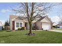 Ranch home with a large tree in the front yard and a two-car garage at 5437 Basin Park Dr, Indianapolis, IN 46239