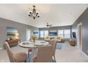 A brightly lit living room features art, hardwood floors, dining table and a modern chandelier at 5437 Basin Park Dr, Indianapolis, IN 46239
