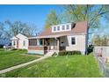 View of a charming home featuring a covered porch, well-maintained lawn, and inviting curb appeal at 550 Trowbridge St, Indianapolis, IN 46203