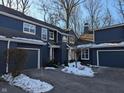 Inviting exterior of a blue home with attached garage and snowy landscaping at 7841 Harbour # 35, Indianapolis, IN 46240