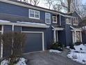 Side view of a lovely blue home with attached garage and winter landscaping at 7841 Harbour # 35, Indianapolis, IN 46240