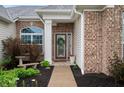 Beautiful front entrance highlighting the brick facade, a decorative wreath, and curated landscaping around the walkway at 8535 Blue Marlin Dr, Indianapolis, IN 46239