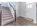 Bright entryway with dark hardwood floors and carpeted staircase at 10854 Descanso Dr, Fishers, IN 46038