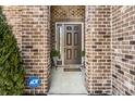 Elegant front entryway featuring a stylish door, brick accents, and manicured greenery, creating a welcoming appeal at 10917 Hunter Lake Ln, Indianapolis, IN 46239