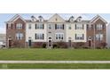 Brick townhouses with attractive landscaping and a well-maintained lawn at 12700 Tamworth Dr, Fishers, IN 46037