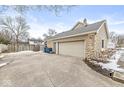 Attached two-car garage with stone facade and concrete driveway at 1271 Spruce Dr, Carmel, IN 46033