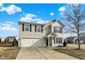 Two-story house with beige vinyl siding, white brick accents, and a two-car garage at 13195 Westwood Ln, Fishers, IN 46038