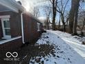 Brick home with snowy backyard and mature trees at 1459 W 33Rd St, Indianapolis, IN 46208
