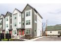 Modern three-story townhouse with gray and white siding, red door, and walkway at 1738 Alloy Dr, Indianapolis, IN 46201