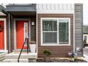 Modern townhouse entrance with red door, gray siding, and potted plants at 1738 Alloy Dr, Indianapolis, IN 46201