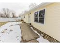 Side view of house with new door and window, snow on ground at 195 E Center Dr, Mooresville, IN 46158