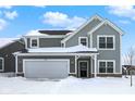 Two-story gray house with a white garage door, snow on the ground at 19723 Atwater Ave, Sheridan, IN 46069