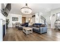 Spacious living area featuring hardwood floors, a large TV, and a modern chandelier at 2301 Nowland Ave, Indianapolis, IN 46201