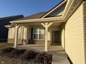 Covered front porch with brick columns and a dark green door at 2746 Lanai Ln, Greenwood, IN 46143