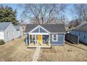 Cute blue bungalow with a yellow door and small front yard at 305 Hamilton St, Fortville, IN 46040