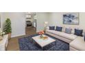 Bright living room with a plush blue rug, neutral sofa with throw pillows, and modern decor at 305 Hamilton St, Fortville, IN 46040