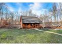 Beautiful exterior view of the home with a cozy front porch in a serene wooded setting at 4104 W Fox Trl, Trafalgar, IN 46181