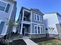 Charming two-story home with gray siding, white trim, covered porch, and a small fenced yard at 549 Gilder Dr, Carmel, IN 46032