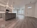 Open-concept kitchen and living area with hardwood floors and island with countertop seating at 549 Gilder Dr, Carmel, IN 46032