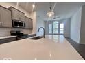 Kitchen island with quartz countertop, stainless steel faucet, and views into the living area at 549 Gilder Dr, Carmel, IN 46032