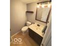 Half bath with gray walls, vanity and mirror, shelf and toilet at 6639 N College Ave, Indianapolis, IN 46220
