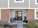 Inviting front entry with brick and siding, black door, and potted plants at 956 Dorchester Dr, Noblesville, IN 46062