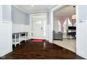 Inviting foyer with hardwood floors, modern trim, and a view of the home office at 10214 Cloverbank Dr, Fishers, IN 46040