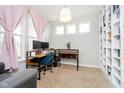 Comfortable home office with built-in shelving and large windows providing ample light at 10214 Cloverbank Dr, Fishers, IN 46040