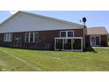 View of the backyard with a brick house, a white fence, and green grass at 11835 Civic Cir, Mooresville, IN 46158