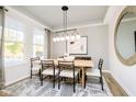 Bright dining room featuring a wood table and modern chandelier at 14378 Bishop Birch Pl, Carmel, IN 46032