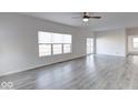 Spacious living area with vinyl plank flooring, ceiling fan, and large windows at 20 Lancaster Ct, Trafalgar, IN 46181
