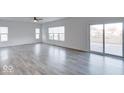 Bright living room with gray vinyl plank flooring and sliding glass doors leading to a deck at 20 Lancaster Ct, Trafalgar, IN 46181