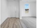 Bright entryway featuring wood-style flooring, a white front door, and a view into the carpeted living room at 349 N Post Oak Dr, Mooresville, IN 46158