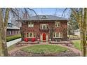 Charming two-story brick home with mature landscaping and a welcoming red front door at 43 W Hampton Dr, Indianapolis, IN 46208