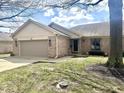 Charming brick home with an attached garage and well-manicured lawn under a partly cloudy sky at 5299 Carnoustie Cir, Avon, IN 46123