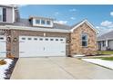 Two-story home with stone and brick accents, two-car garage, and a landscaped front yard at 6433 Wasco Dr, Whitestown, IN 46075