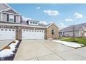 Two-story home with stone and brick accents, two-car garage, and a landscaped front yard at 6433 Wasco Dr, Whitestown, IN 46075