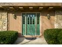 Close up of the front door, flanked by traditional sconces, and manicured shrubs at 662 Morningside Dr, Zionsville, IN 46077