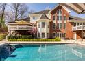 Rear exterior with a deck, swimming pool, brick facade, and plenty of windows for natural light at 7341 Washington Blvd, Indianapolis, IN 46240